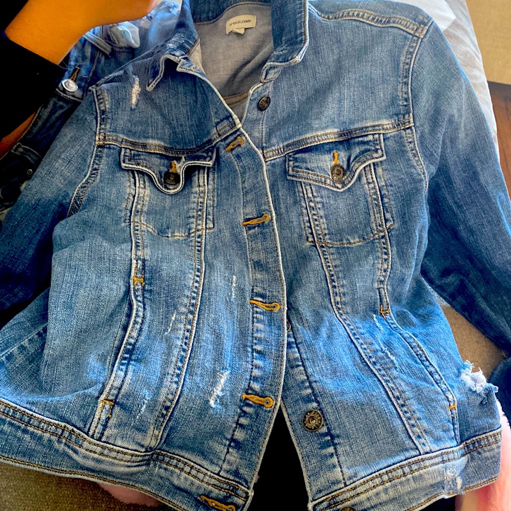 Medium-wash lightweight distressed denim jacket.